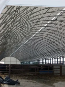 Low profile clearance double pipe truss building with road salt materials inside.