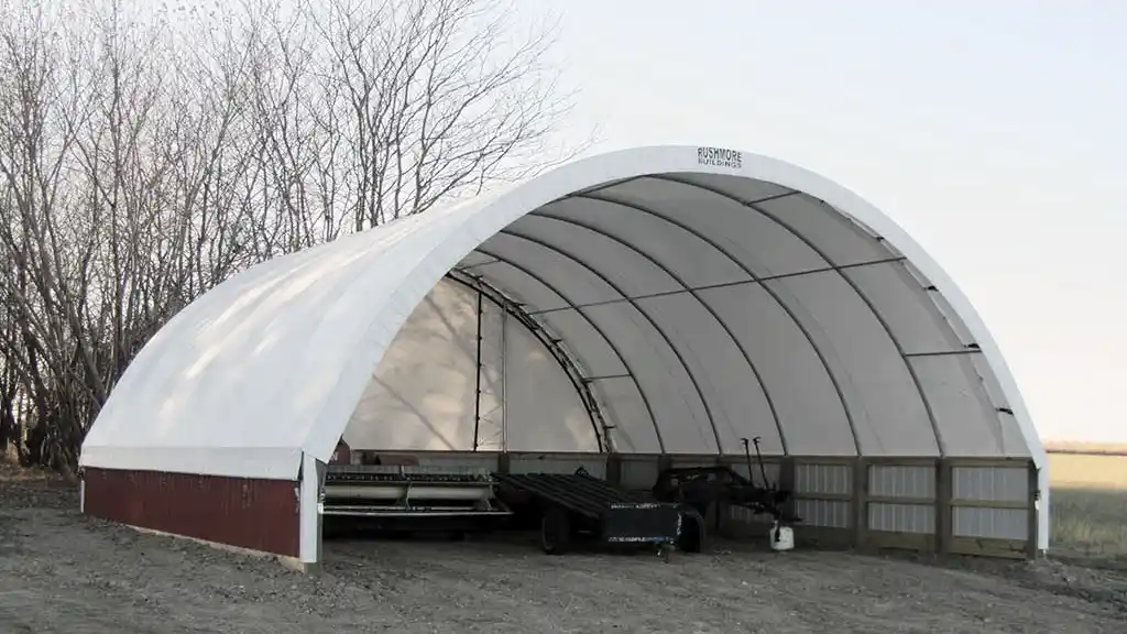 24 foot wide farm storage hoop barn with one end and equipment inside