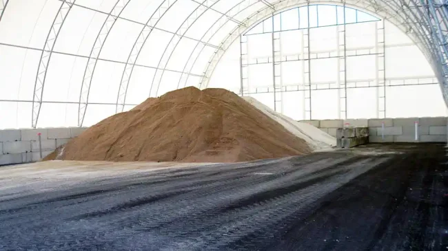 Piled sand in a high profile hoop building